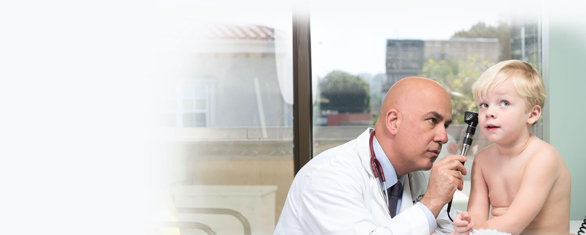 Doctor Pedram Salimpour Checking a Young Patient's Ear