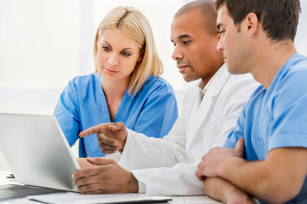 physician and staff checking laptop